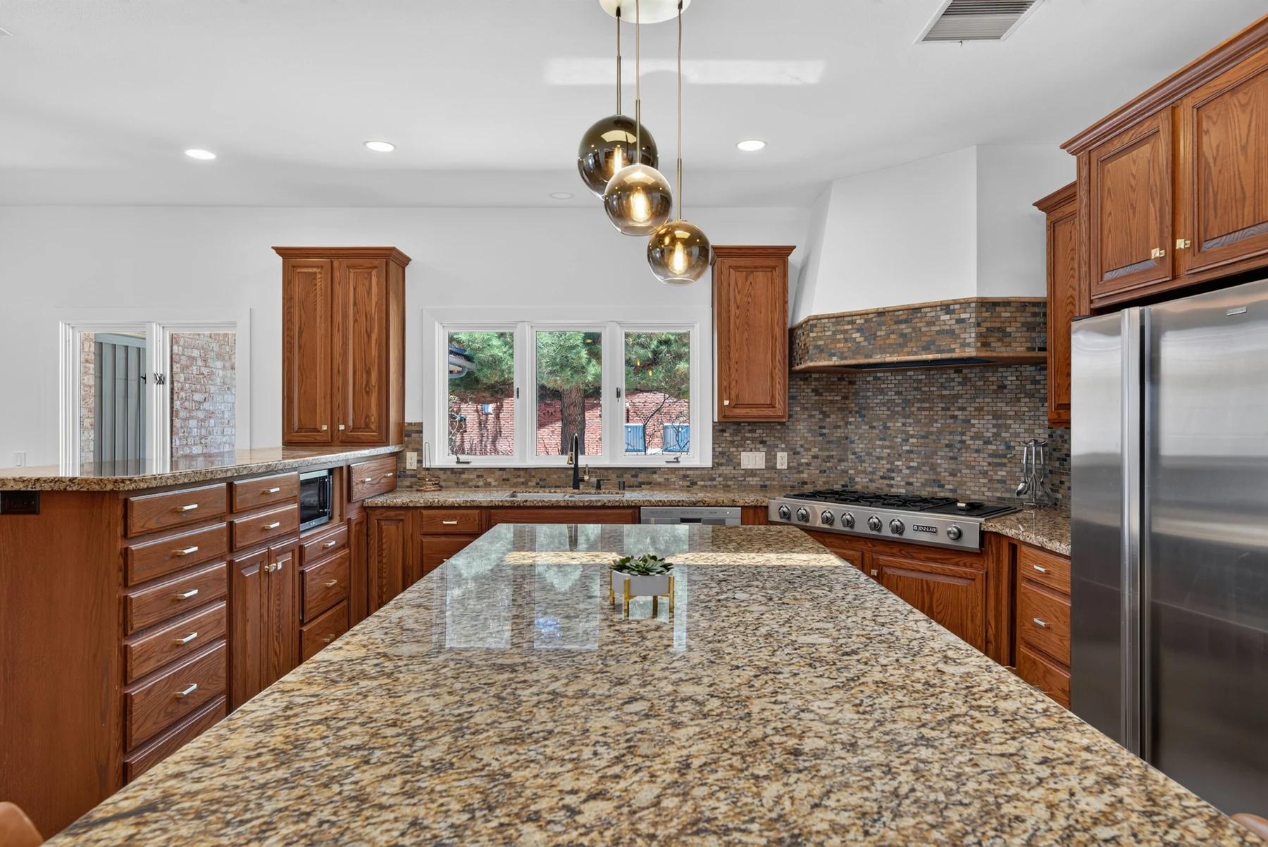 Kitchen with wood cabinetry and stone counters